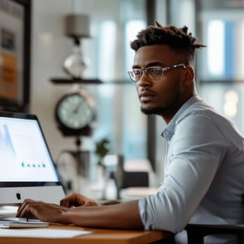 employee working at desk with a clock in the background